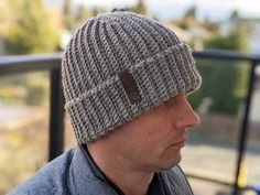 a man wearing a knitted hat looks off into the distance