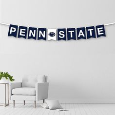 the penn state banner is hanging in front of a white chair with a potted plant next to it