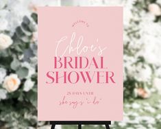 a pink wedding shower sign with flowers in the background