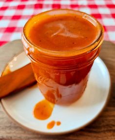 a jar of sauce sitting on top of a white plate