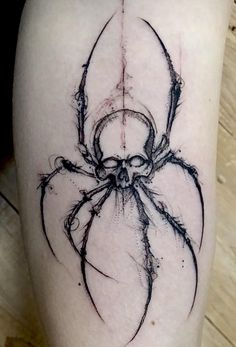 a spider tattoo on the leg of a person's leg, it is black and white