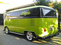 a lime green van parked in front of a house with the word vw on it's side