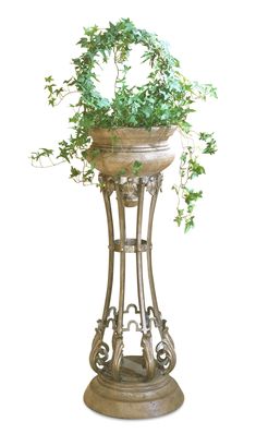 a potted plant sitting on top of a metal stand with ivy growing out of it