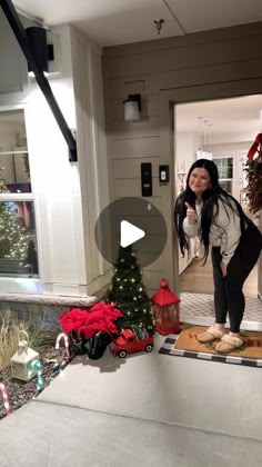 a woman standing in front of a christmas tree