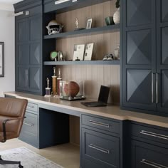 a home office with built - in cabinets and leather chair