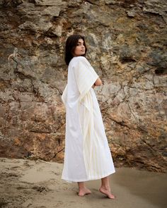 A semi-sheer, straight-cut caftan with a deep v-neck and slits on each side. This lightweight cotton piece with yellow stripes effortlessly transcends between seasons. - One size - Color: white - Fabric: Handwoven cotton - Length: 51” White V-neck Kaftan For Daywear, Chic White V-neck Kaftan, White V-neck Summer Kaftan, White Floor-length Summer Kaftan, Casual Yellow V-neck Kaftan, Spring Striped Kaftan For Beach Cover-up, Casual Striped V-neck Kaftan, Yellow Stripes, White Fabric