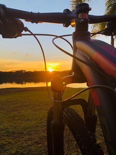 the sun is setting behind a mountain bike