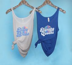 two tank tops hanging up against a blue background