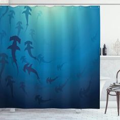 a blue shower curtain with silhouettes of people swimming in the water