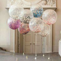 balloons with confetti on them in front of a fireplace