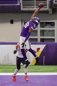 two football players are jumping in the air