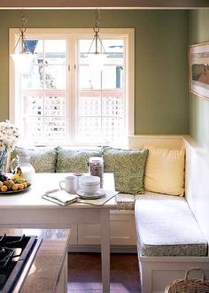 a kitchen with a table, bench and window