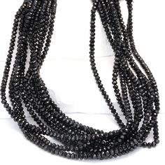 Black Spinel 3mm Faceted Rondelles Bead Strand Experience the allure of our 13" Full Bead Strand of Black Spinel Faceted Rondelles. These 3mm beads are meticulously crafted, boasting a deep, rich black hue that adds a touch of sophistication to any jewelry design. As a gemstone wholesaler, we ensure that each bead is cut to perfection, highlighting the unique facets of the Black Spinel. This gemstone is known for its durability and intense color, making it a favorite among jewelry designers and stores. Whether you're creating a statement necklace or a simple bracelet, these Black Spinel Faceted Rondelles will elevate your designs with their captivating beauty. Specifications: Gemstone: Black Spinel Shape: Faceted Rondelles Size: 3mm - 3.5mm Strand Length: 13" Pieces per Strand: ~135 Drill Black Rondelle Beaded Necklaces, Black Beaded Rondelle Necklace, Elegant Black Rondelle Beaded Necklaces, Elegant Multi-strand Spacer Beads, Elegant Black Faceted Beads, Color Making, Simple Bracelets, Jewelry Designers, Black Spinel