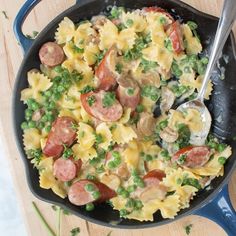 a skillet filled with pasta, peas and sausage