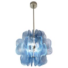 a blue flower shaped light hanging from a ceiling fixture