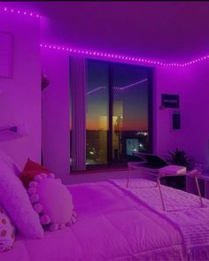 a bedroom with purple lights on the ceiling and bed in front of a large window