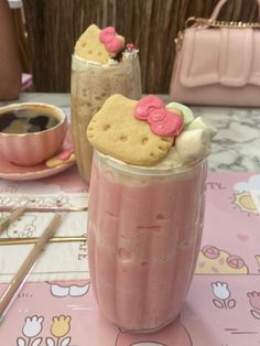 two hello kitty cookies and milkshakes are sitting on a table next to a pink purse