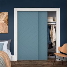 a bedroom with blue walls and an open closet door that is next to a bed