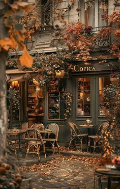 the outside of a restaurant with tables and chairs in front of it, surrounded by autumn foliage