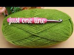 a green ball of yarn with a crochet hook on it that says just one line