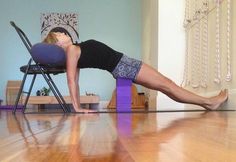 a woman in black shirt and shorts doing exercises on purple chair