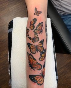 a woman's arm with many butterflies on it