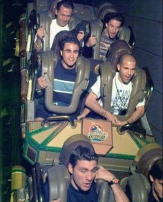 a group of men riding on top of a roller coaster