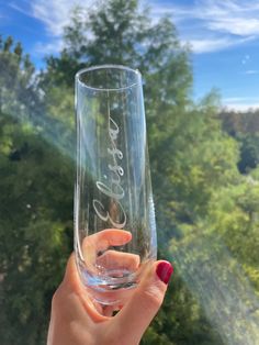 a woman holding up a wine glass with the word love written in cursive writing on it