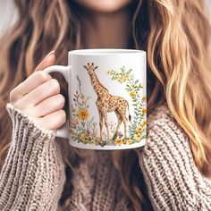 a woman holding a coffee mug with a giraffe on it