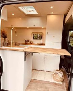 the interior of a camper van with an open kitchen and dining area in it