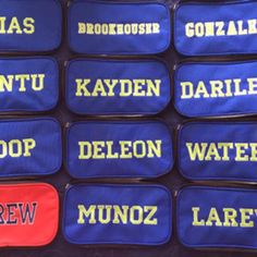 several blue and yellow bags with names on them