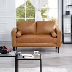 a living room with two couches and a coffee table in front of a window