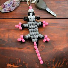 a keychain made out of beads and keys on top of a wooden table