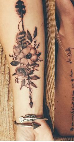 two women with tattoos on their arms and one has a flower tattoo on her arm