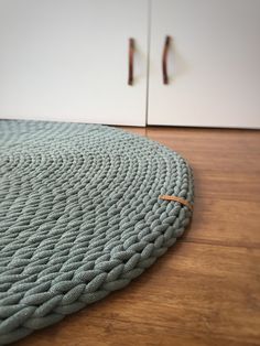 a close up of a rug on the floor near a cabinet with handles in it