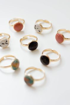 six rings with different shapes and colors on them sitting on a white surface in front of each other