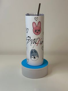 the tumbler is decorated with cartoon characters and has a straw sticking out of it