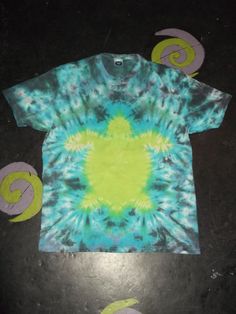 a tie - dyed t - shirt is laying on the floor with circles around it