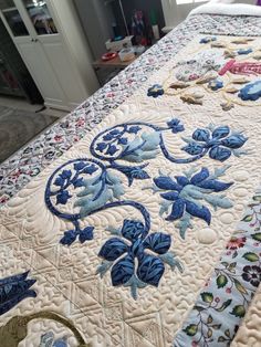 a quilted bed with blue and white flowers on it