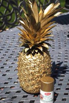 a gold pineapple sitting on top of a table next to a bottle of deodorant