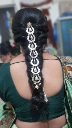 the back of a woman's head with long black hair and an intricate braid