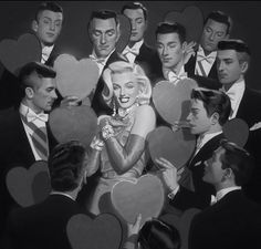 a black and white photo of marilyn monroe surrounded by heart - shaped cardboard cutouts