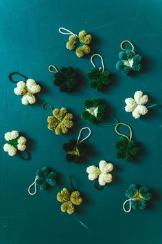 crocheted broccoli and clovers are arranged on a blue surface with white string