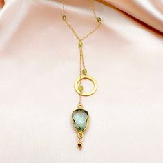 Our ballet collection is designed to be both modern and feminine. Pairing a beautiful circle accent with a green amethyst gemstone (also known as prasiolite) in the graceful, signature design of our ballet necklace. 14k gold plated over fine Italian silver. Necklace chain is adjustable up to 2”.Total chain length with drop is 19".Handmade. Chic Gold Necklace With Gemstone, Chic Gold Necklaces With Gemstone, Elegant Green Amethyst Jewelry For Gifts, Elegant Faceted May Birthstone Necklaces, Elegant Adjustable Necklace With Gemstone Accents, Gold Jewelry With Green Amethyst Birthstone, Gift Green Amethyst Gold Necklaces, Gift Gold Necklaces With Green Amethyst, Elegant Faceted Green Amethyst Jewelry