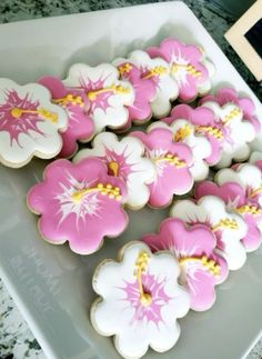 some pink and white decorated cookies on a plate