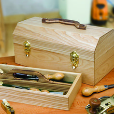 a wooden box with tools in it sitting on a table