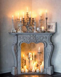 a mantel with candles and pictures on it