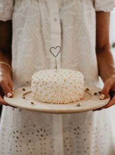 a woman holding a plate with a cake on it