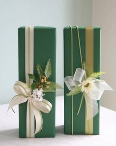 two green boxes with bows and flowers on them