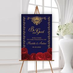 a blue and red wedding sign on an easel next to a vase with flowers